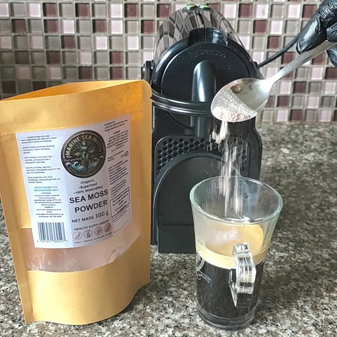 Sea Moss Powder being spooned into coffee cup next to Nespresso machine